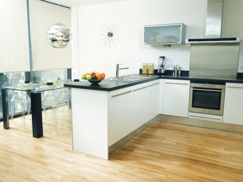 Foto di una piccola sala da pranzo aperta verso la cucina contemporanea con pareti bianche, pavimento in bambù e pavimento beige