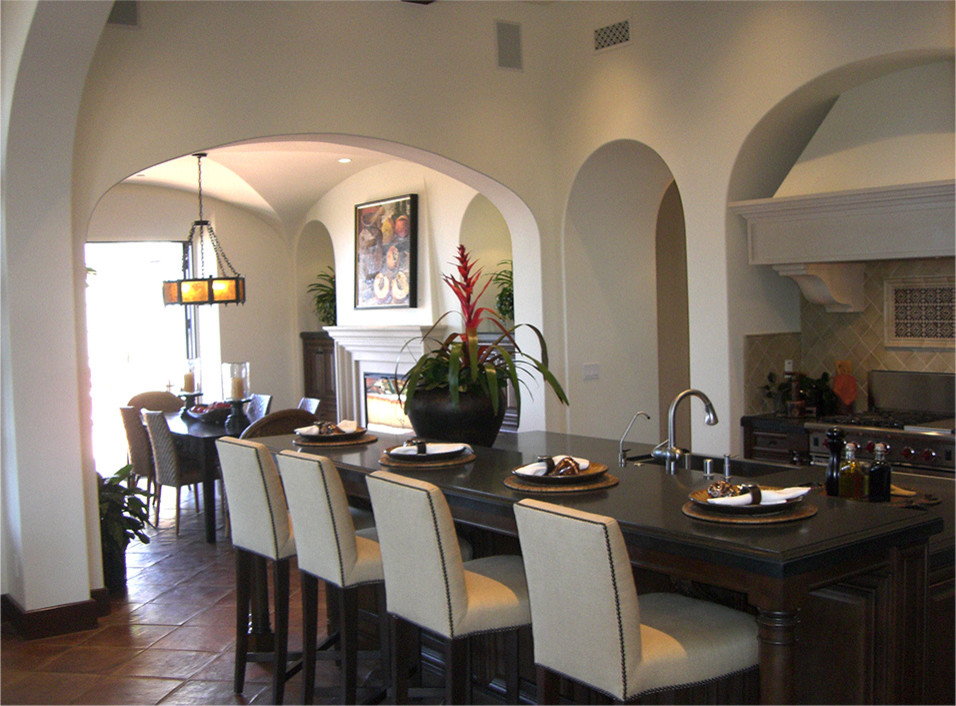 This is an example of an expansive mediterranean kitchen/dining room in Los Angeles with white walls, terracotta flooring and a standard fireplace.