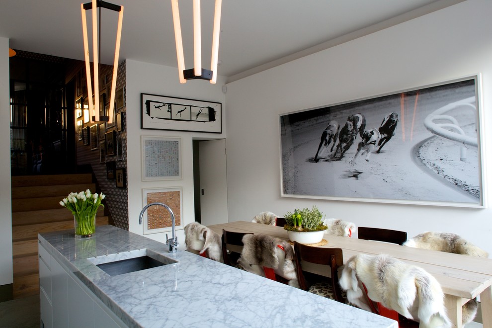 Immagine di una sala da pranzo aperta verso la cucina minimal di medie dimensioni con pareti bianche e pavimento in cemento