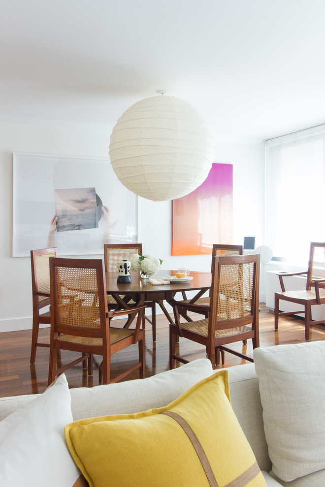 Esempio di una sala da pranzo aperta verso il soggiorno minimal di medie dimensioni con pareti bianche, pavimento in legno massello medio e pavimento marrone