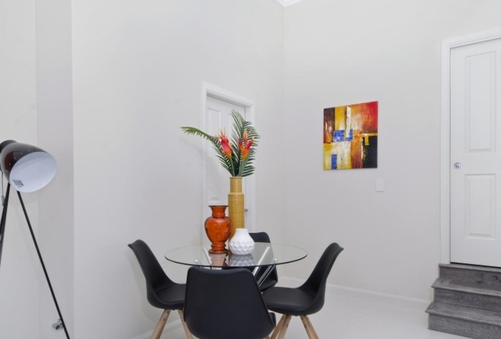 This is an example of a small modern open plan dining room in Sydney with porcelain flooring, no fireplace and white floors.