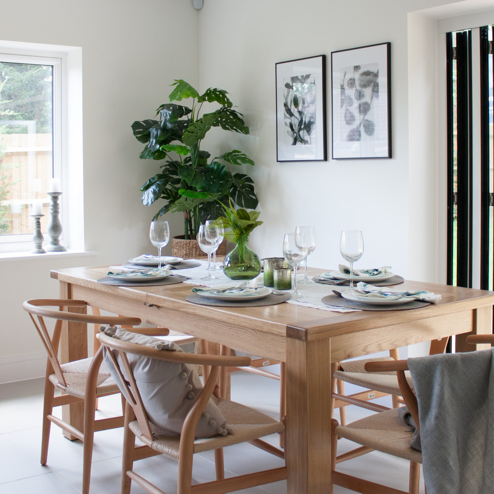 Aménagement d'une salle à manger contemporaine de taille moyenne et fermée avec un mur blanc et un sol blanc.