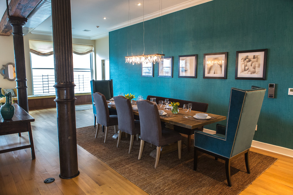 This is an example of a large contemporary open plan dining room in New York with blue walls and light hardwood flooring.