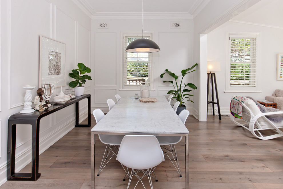 Esempio di una sala da pranzo aperta verso il soggiorno scandinava di medie dimensioni con pareti bianche, pavimento in laminato e pavimento grigio