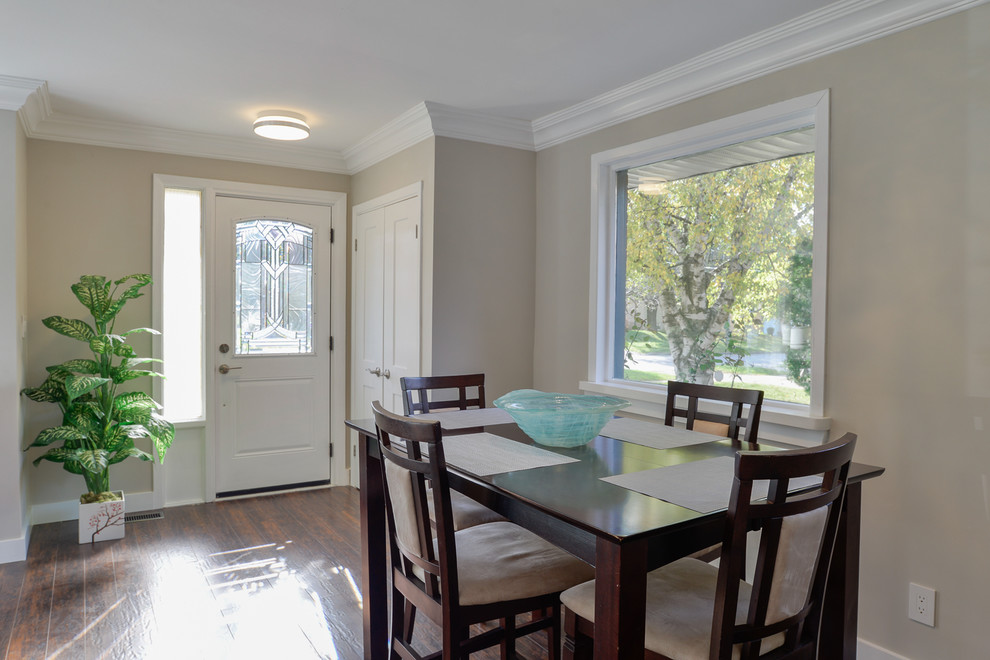 Idee per una sala da pranzo aperta verso il soggiorno minimalista di medie dimensioni con pareti beige, pavimento in laminato, nessun camino e pavimento marrone