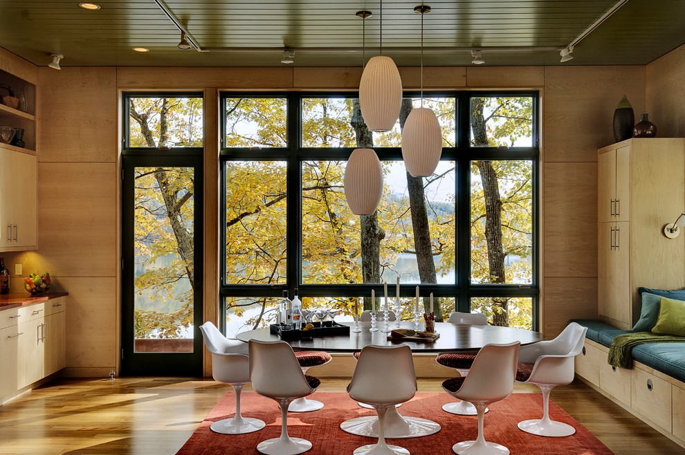 Esempio di una sala da pranzo design con pavimento in legno massello medio