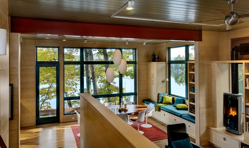 Modernes Esszimmer mit braunem Holzboden und Kaminofen in Burlington
