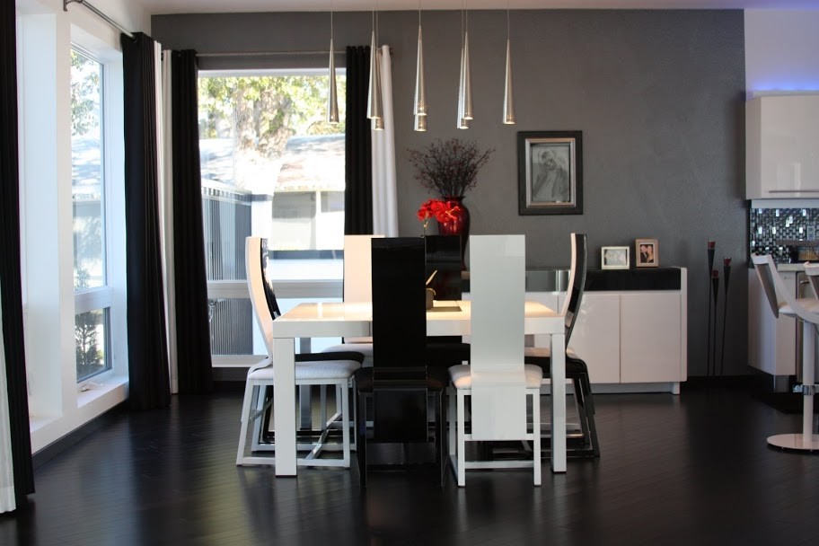 Exemple d'une salle à manger ouverte sur la cuisine tendance de taille moyenne avec un mur gris, un sol noir et parquet foncé.