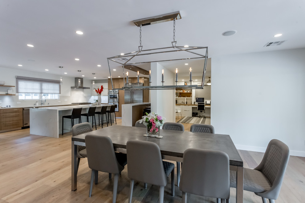 Photo of a large contemporary open plan dining room in San Francisco with white walls, medium hardwood flooring, a standard fireplace, a tiled fireplace surround and brown floors.