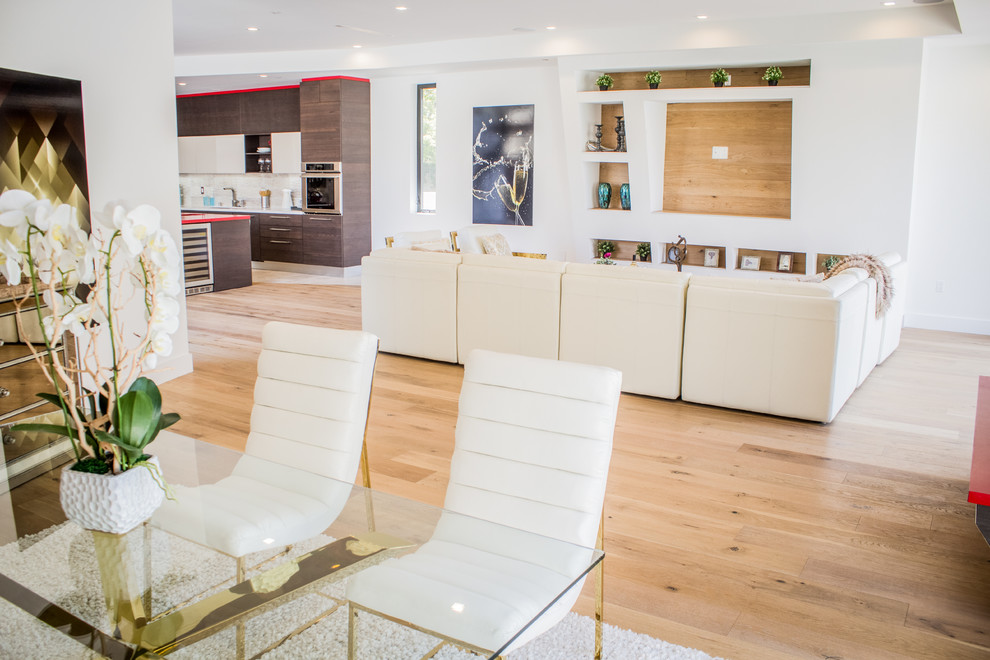 Inspiration pour une petite salle à manger ouverte sur le salon design avec un mur blanc, un sol en bois brun, une cheminée ribbon, un manteau de cheminée en métal et un sol marron.