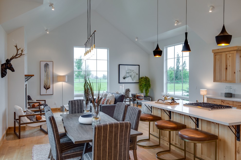 Foto di una grande sala da pranzo aperta verso la cucina contemporanea con pareti bianche, parquet chiaro, nessun camino e pavimento marrone