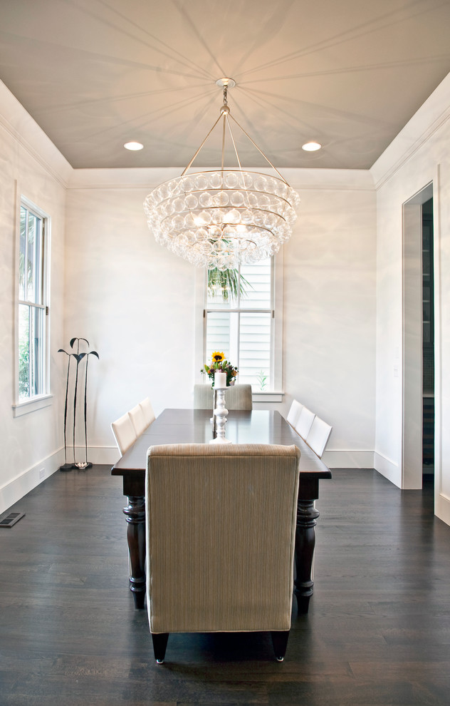 This is an example of a contemporary dining room in Charleston with white walls and dark hardwood flooring.