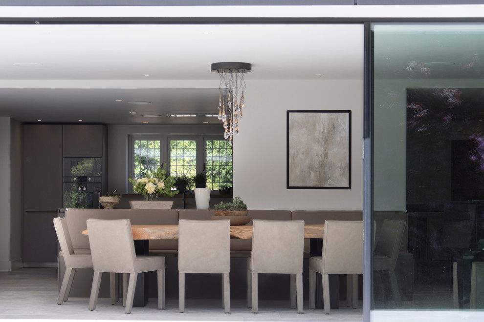 Design ideas for a large contemporary open plan dining room in Cheshire with white walls, ceramic flooring, a wood burning stove, a plastered fireplace surround and white floors.