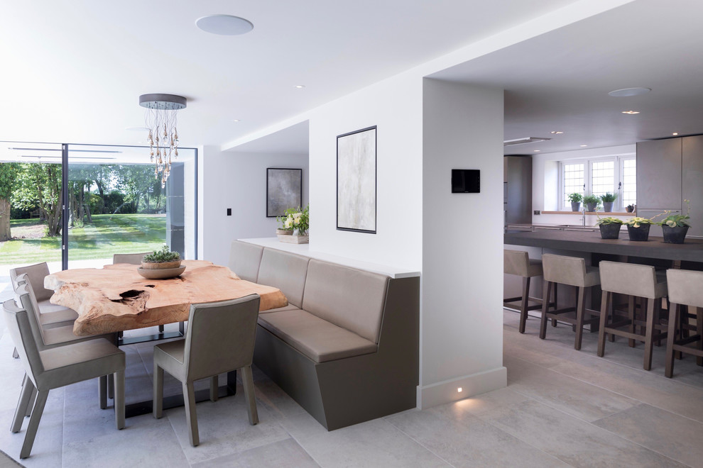 Exemple d'une grande salle à manger ouverte sur le salon tendance avec un mur blanc, un sol en carrelage de céramique, un poêle à bois, un manteau de cheminée en plâtre et un sol blanc.
