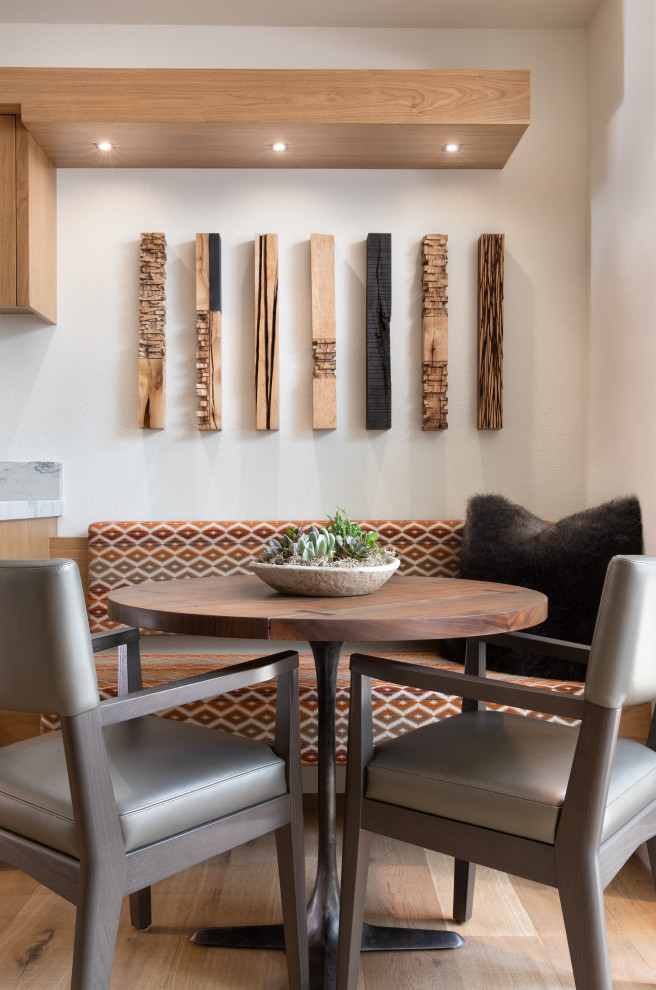 Idées déco pour une salle à manger contemporaine avec une banquette d'angle, un mur blanc, parquet clair et un sol beige.