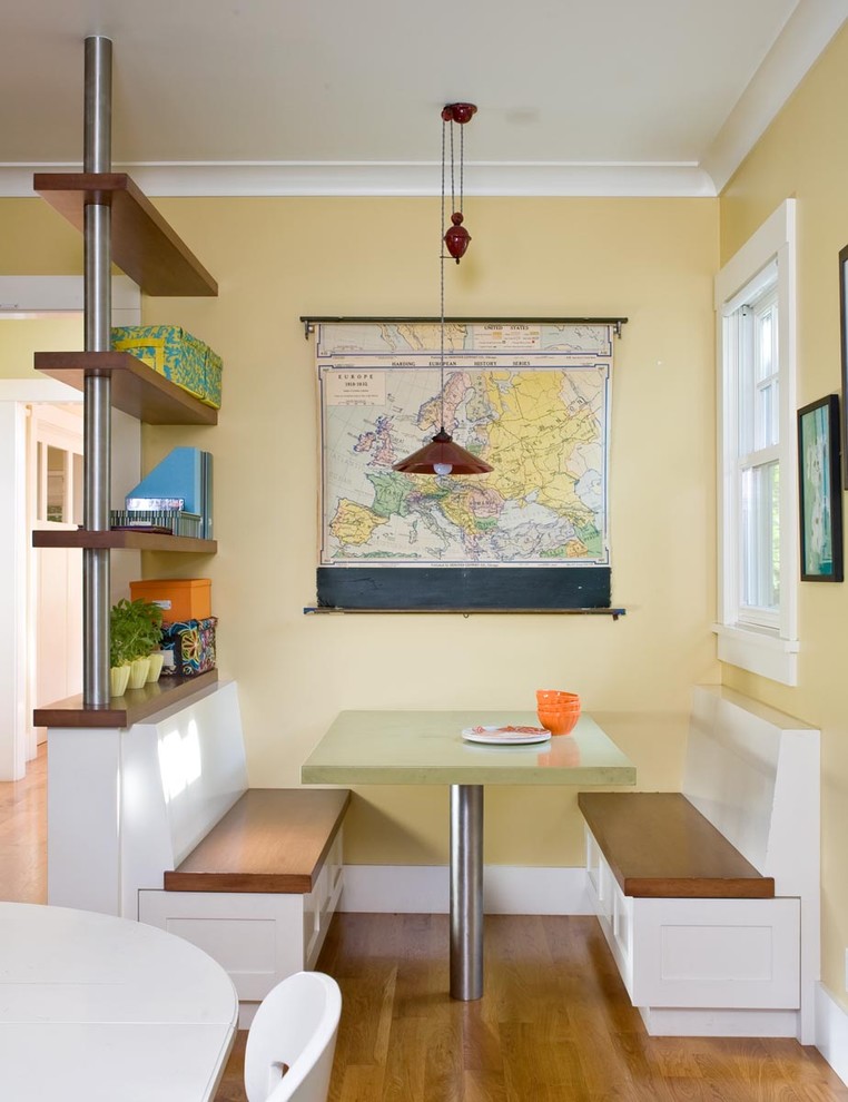 Immagine di una sala da pranzo aperta verso la cucina design con pavimento in legno massello medio