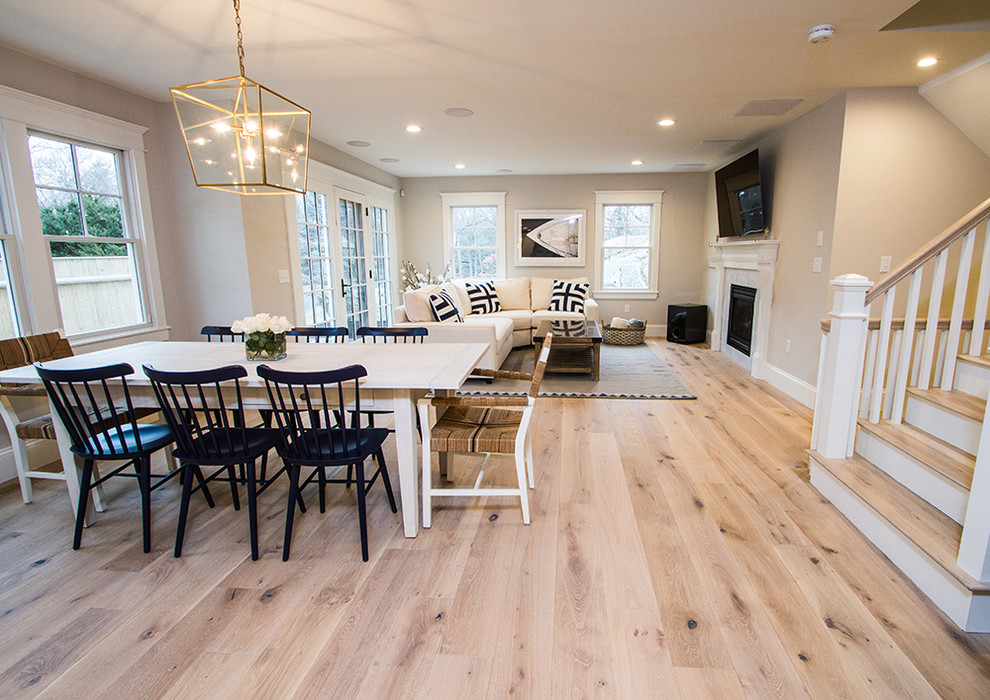 Medium sized contemporary open plan dining room in Boston with grey walls, light hardwood flooring, a standard fireplace and a tiled fireplace surround.