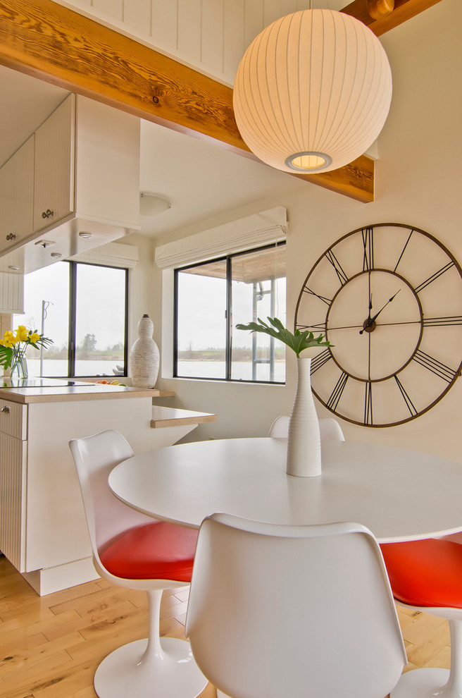 Foto di una sala da pranzo aperta verso la cucina design con pareti bianche e pavimento in legno massello medio