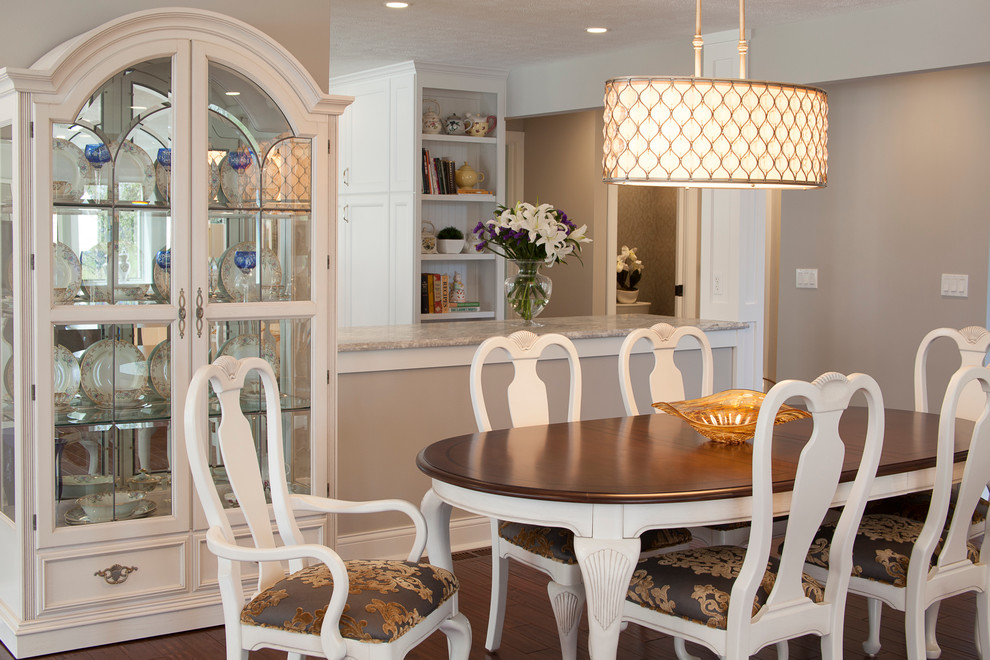 Idée de décoration pour une salle à manger ouverte sur la cuisine design avec un mur beige et un sol en bois brun.
