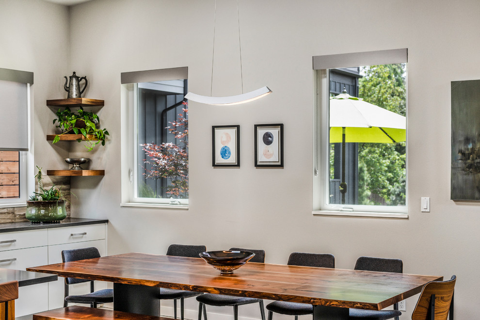 Réalisation d'une salle à manger ouverte sur la cuisine design avec un mur gris, sol en béton ciré et un sol multicolore.