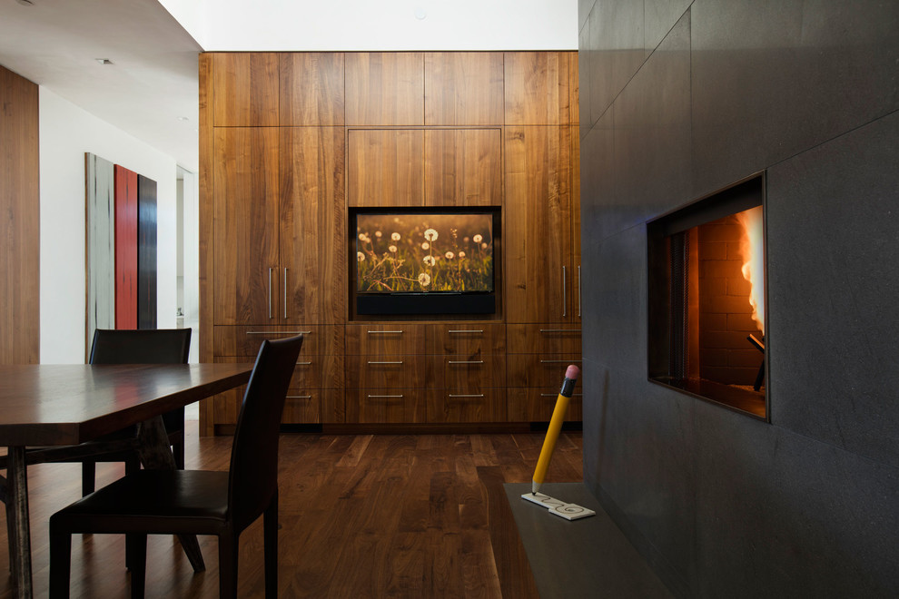 Idee per una sala da pranzo minimal con pavimento in legno massello medio, camino classico e cornice del camino in pietra