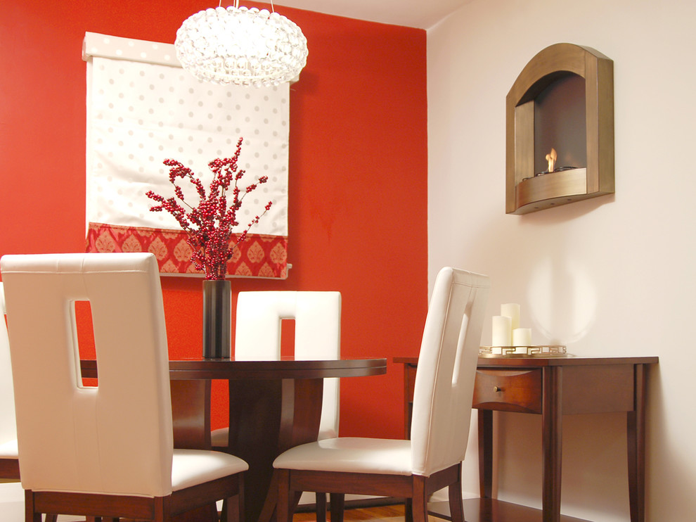 Inspiration pour une salle à manger design avec un mur rouge.