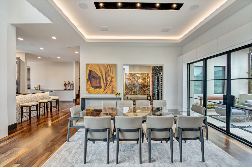Photo of an expansive contemporary open plan dining room in Orange County with white walls, medium hardwood flooring and brown floors.