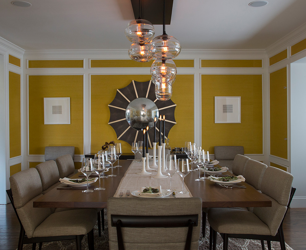 Cette image montre une salle à manger design fermée et de taille moyenne avec un mur jaune, parquet foncé, aucune cheminée et un sol marron.