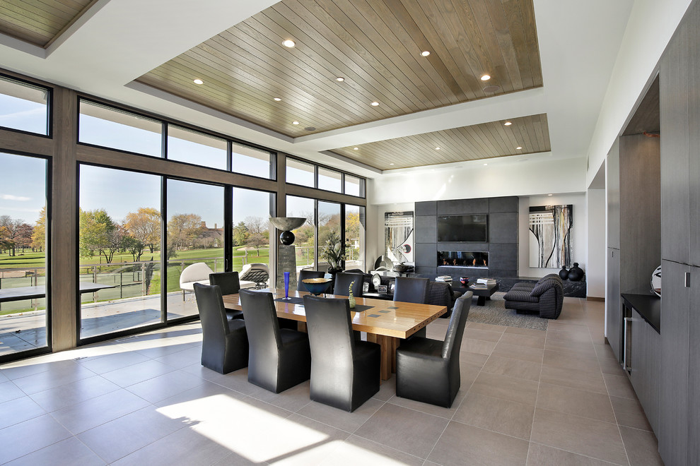 Medium sized contemporary open plan dining room in Chicago with a ribbon fireplace, a stone fireplace surround, white walls, porcelain flooring and beige floors.