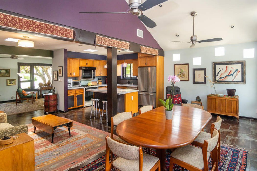 Immagine di una sala da pranzo aperta verso il soggiorno design di medie dimensioni con pareti viola, pavimento in gres porcellanato e soffitto a volta
