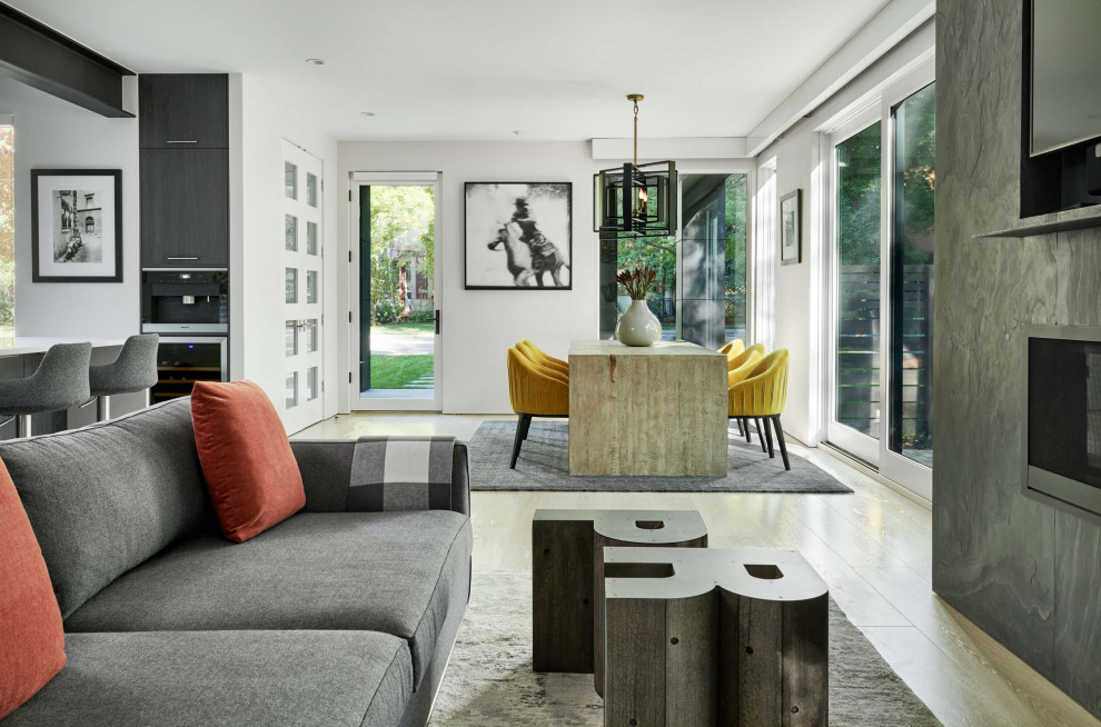 Идея дизайна: гостиная-столовая среднего размера в стиле модернизм с белыми стенами, светлым паркетным полом, горизонтальным камином, фасадом камина из камня и коричневым полом