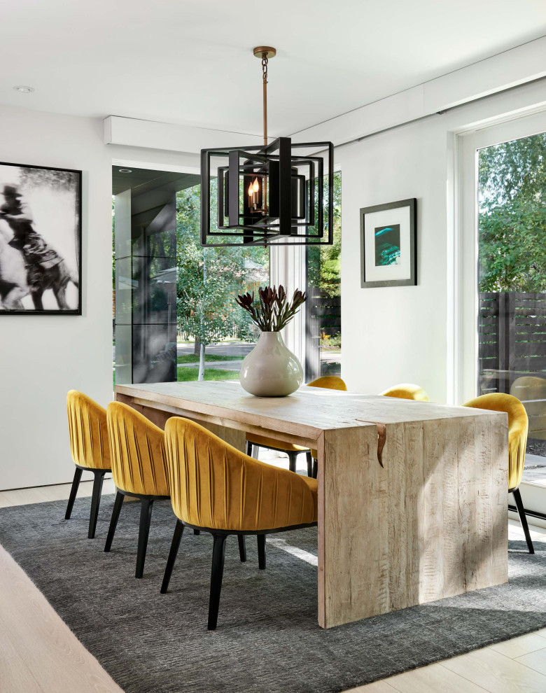 Idée de décoration pour une salle à manger ouverte sur le salon design de taille moyenne avec un mur blanc, parquet clair et un sol beige.