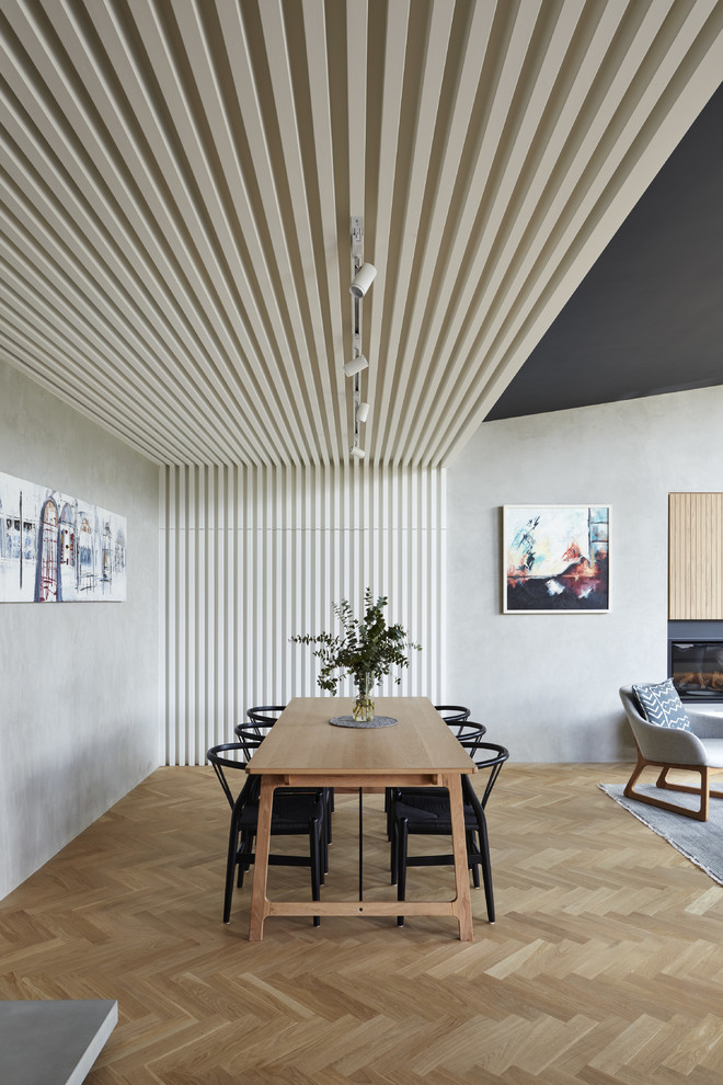Ispirazione per una sala da pranzo aperta verso il soggiorno minimal di medie dimensioni con pareti grigie e parquet chiaro