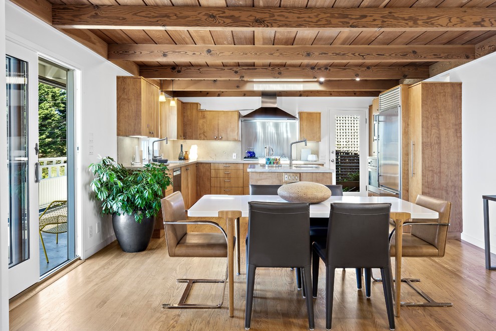 На фото: кухня-столовая в современном стиле с белыми стенами, паркетным полом среднего тона и коричневым полом