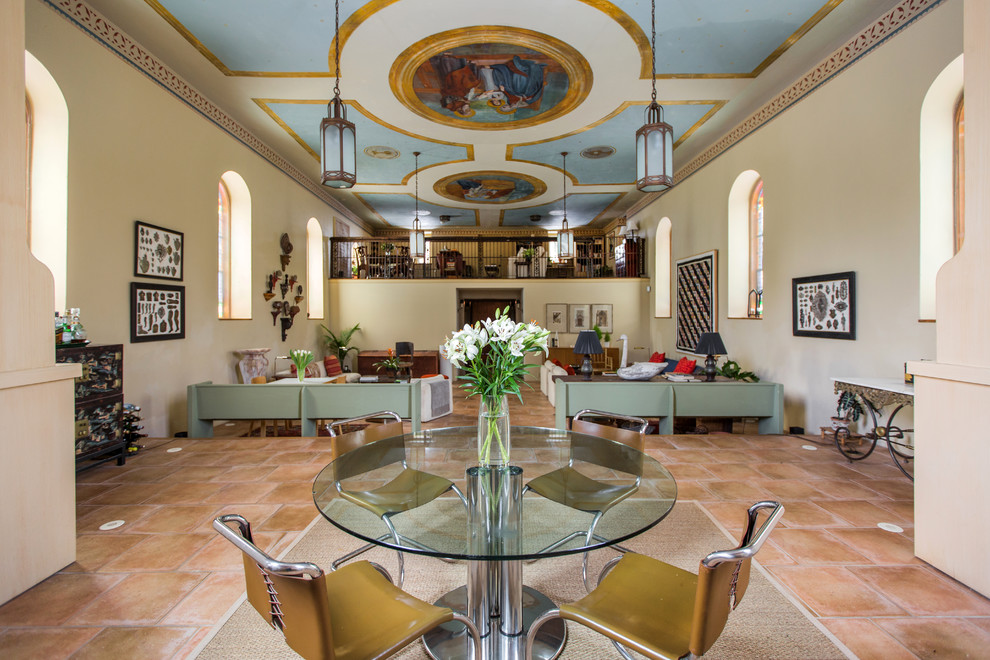 Aménagement d'une grande salle à manger ouverte sur le salon classique avec un mur beige, un sol en travertin, aucune cheminée et un sol rouge.
