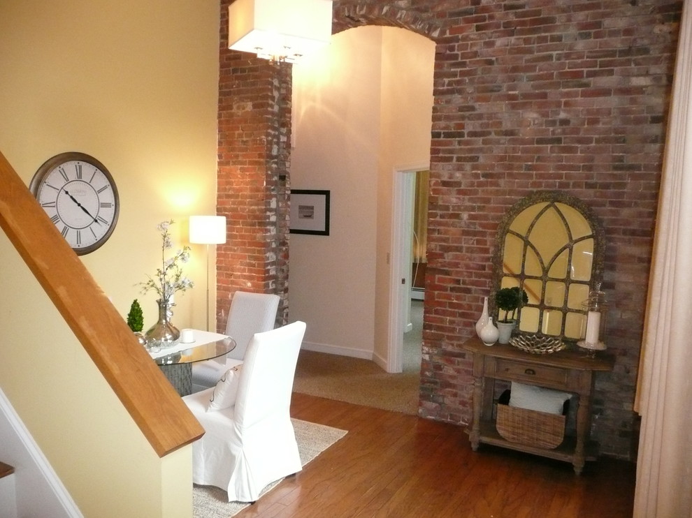 Geschlossenes, Kleines Eklektisches Esszimmer ohne Kamin mit gelber Wandfarbe und braunem Holzboden in Boston