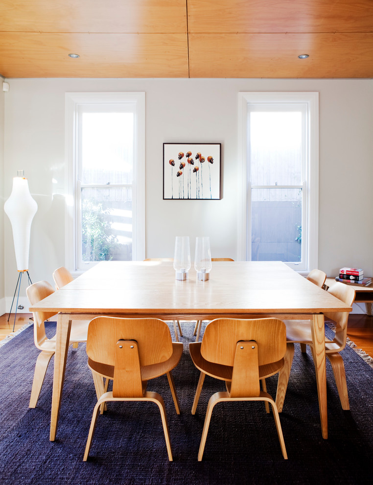 Medium sized midcentury dining room in Sydney with white walls and medium hardwood flooring.