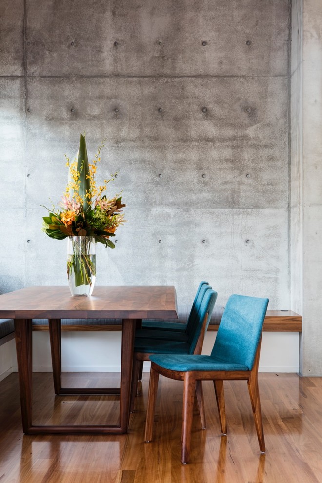 На фото: столовая в современном стиле с серыми стенами, паркетным полом среднего тона и коричневым полом