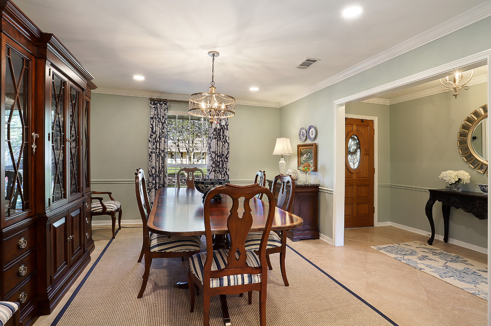 This is an example of a medium sized traditional enclosed dining room in New Orleans with porcelain flooring, no fireplace, beige floors and green walls.
