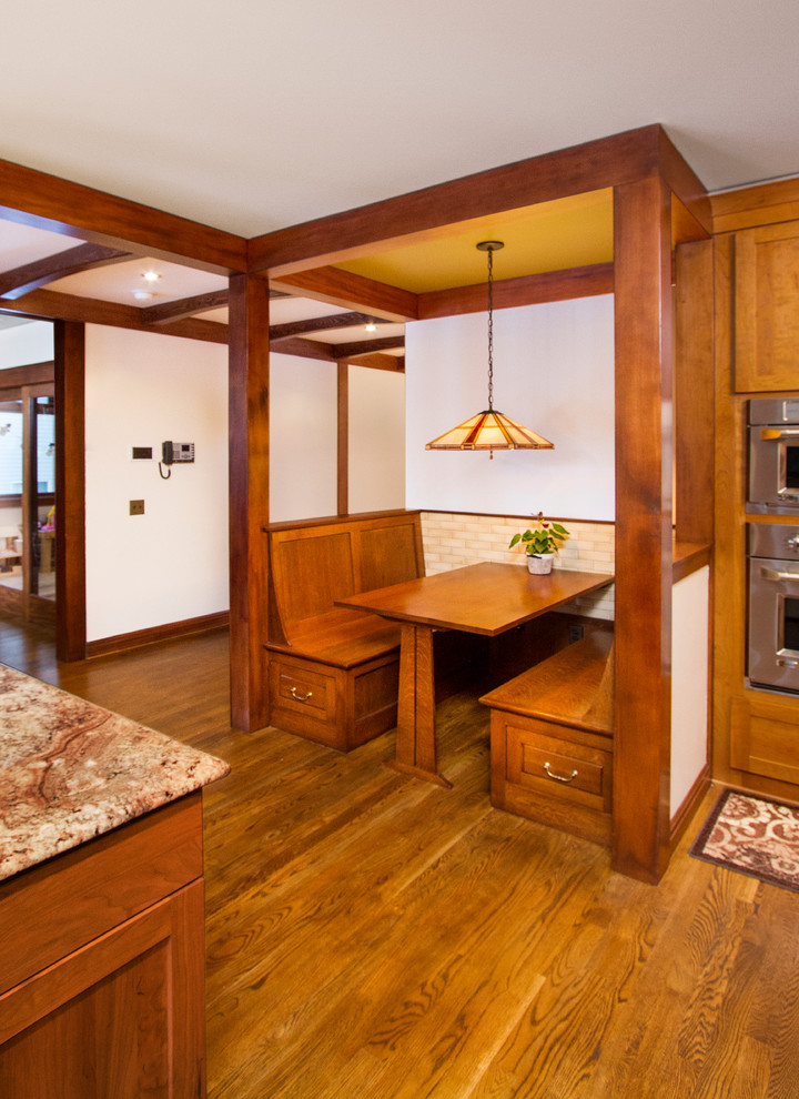 Foto di una sala da pranzo aperta verso la cucina stile americano di medie dimensioni con pavimento in legno massello medio, pareti bianche, nessun camino e pavimento marrone