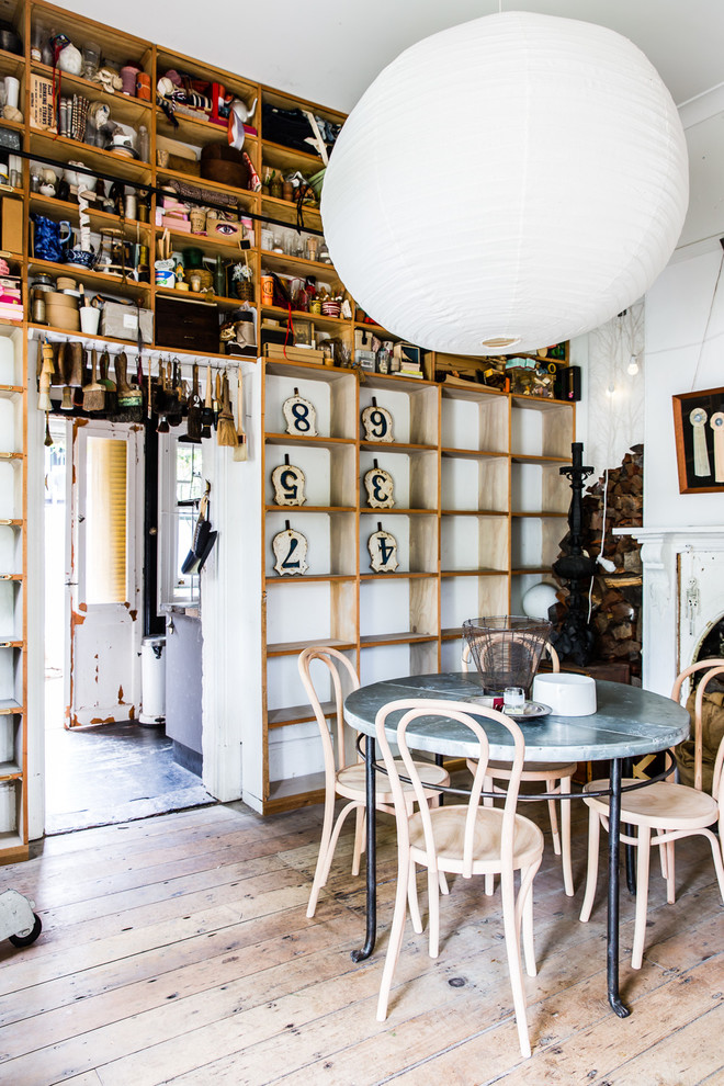 Immagine di una sala da pranzo aperta verso la cucina boho chic con pareti bianche e parquet chiaro