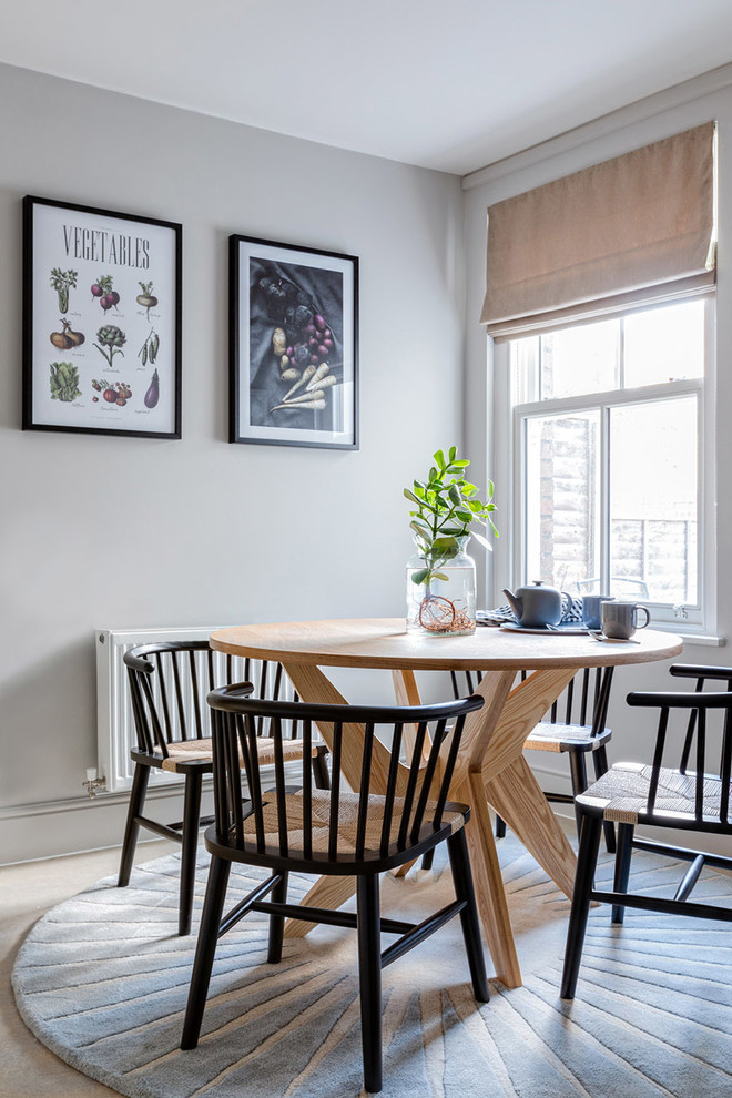 Cette image montre une petite salle à manger ouverte sur la cuisine design avec un mur gris.