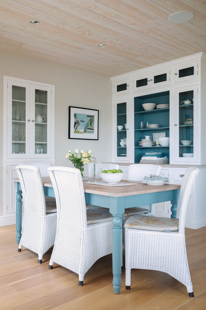 Design ideas for a coastal dining room in Other with beige walls, brown floors and medium hardwood flooring.