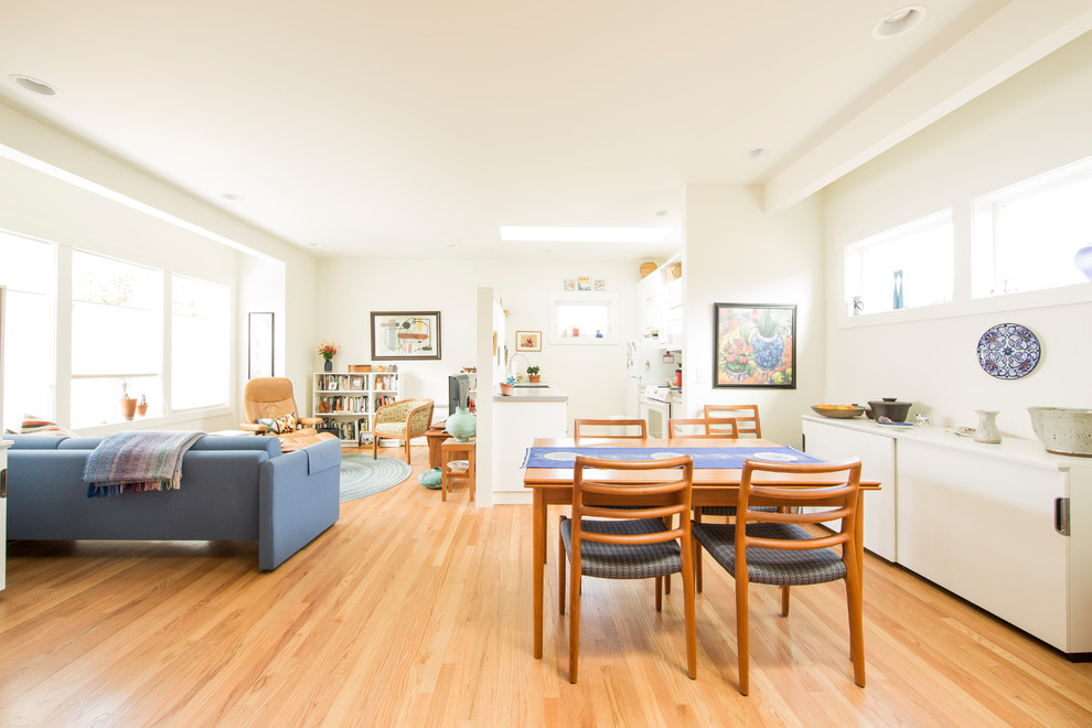 Idee per una sala da pranzo aperta verso il soggiorno contemporanea con pareti bianche, pavimento in legno massello medio e pavimento marrone