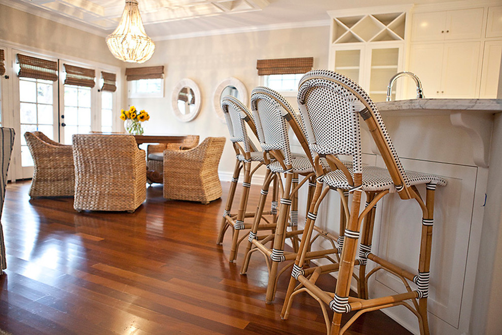 Example of a mid-sized beach style medium tone wood floor enclosed dining room design in San Diego with beige walls and no fireplace