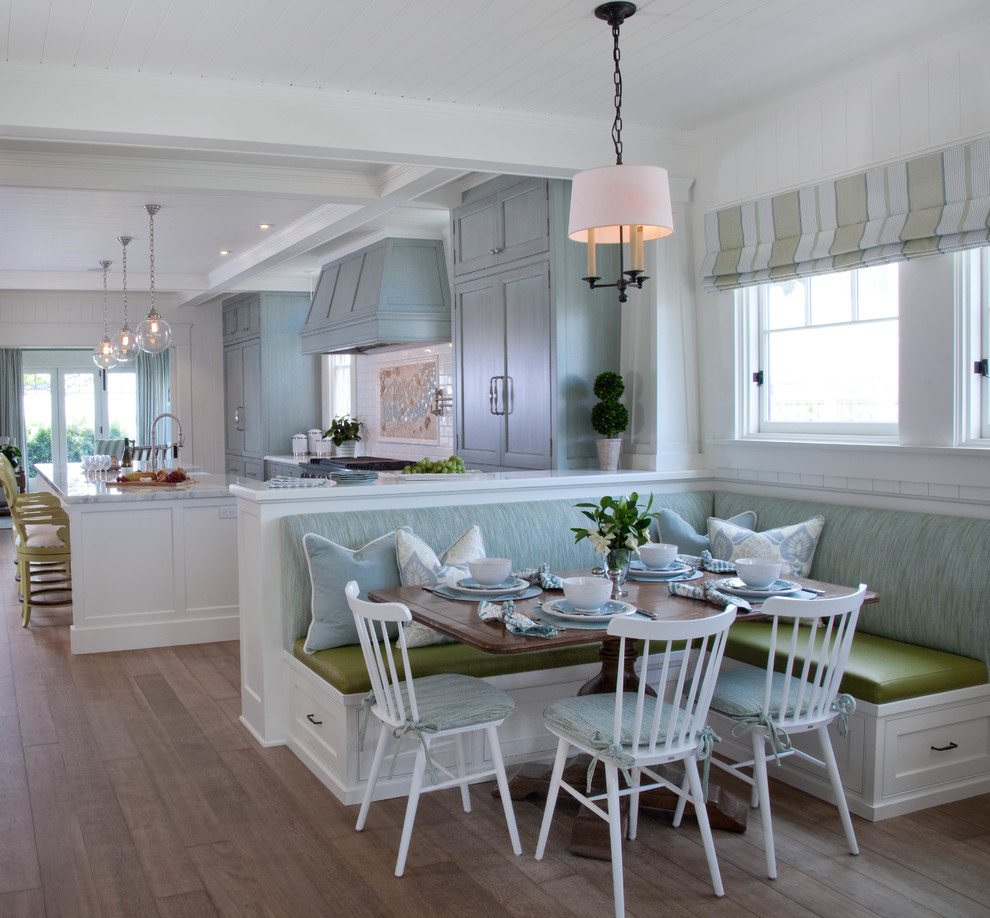 Idee per una sala da pranzo aperta verso la cucina costiera con pareti bianche e pavimento in legno massello medio