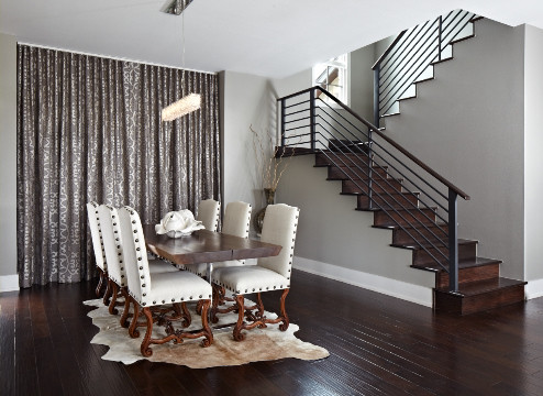Cette image montre une salle à manger ouverte sur le salon design de taille moyenne avec un mur gris et parquet foncé.