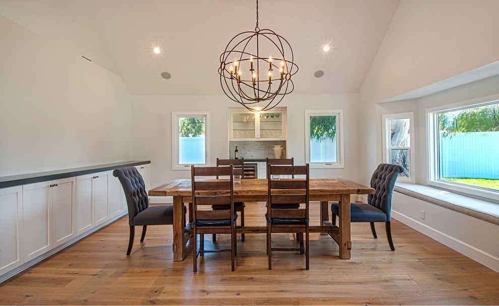 Inspiration for a large coastal light wood floor enclosed dining room remodel in Orange County with white walls and no fireplace