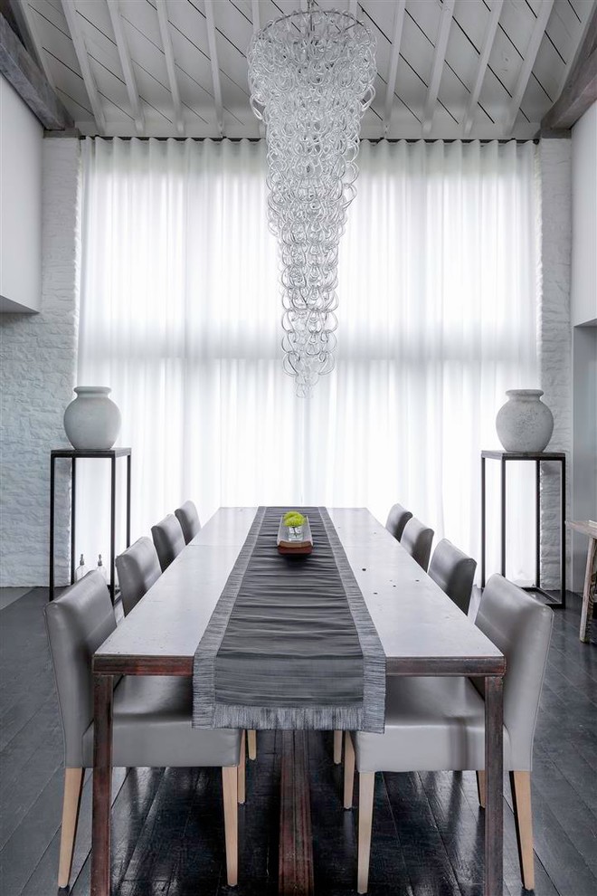 Cette image montre une salle à manger design avec un mur gris et parquet foncé.