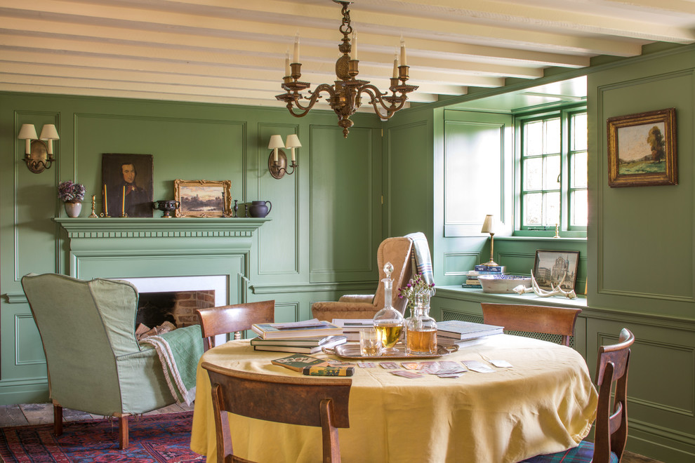 Cette photo montre une salle à manger nature fermée et de taille moyenne avec un mur vert, un sol en bois brun, une cheminée standard, un manteau de cheminée en bois, un sol marron et éclairage.
